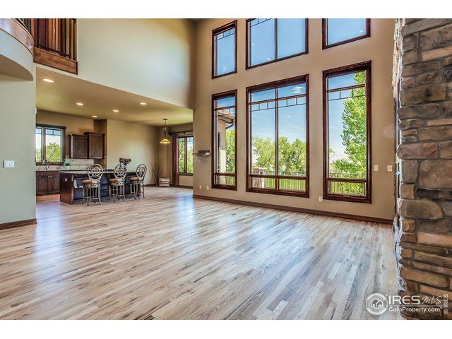 large empty home with brown windows and stone fireplace
