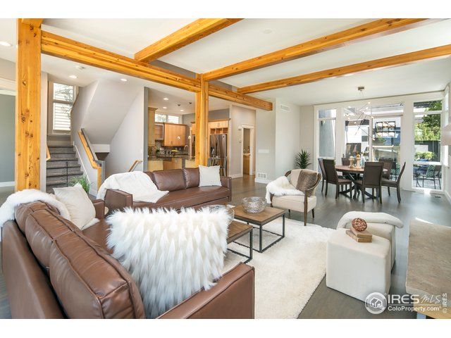 wood beams throughout living room space paired with brown leather furniture and tan details
